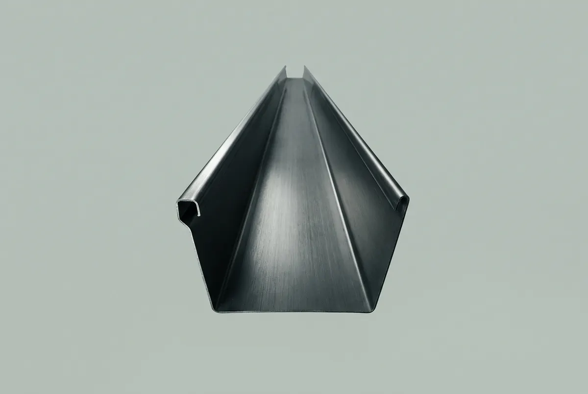 A deep angular box-profile gutter section seen end-on in dark formed metal, floating against a pale ground.